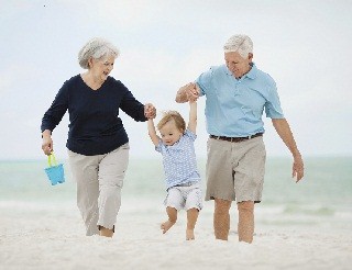 grandparents and child in sand - 320x246